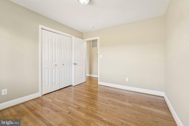 unfurnished bedroom featuring a closet and light hardwood / wood-style floors