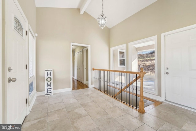 entryway with beamed ceiling, high vaulted ceiling, and a chandelier