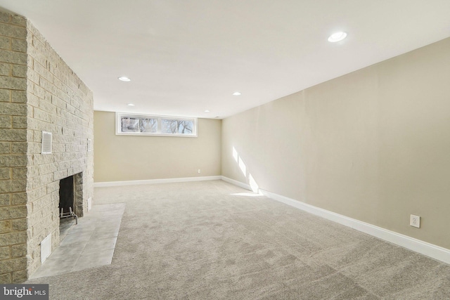 basement with light carpet and a brick fireplace