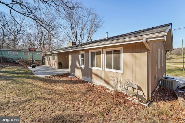 view of home's exterior featuring central AC unit, a patio area, and a lawn