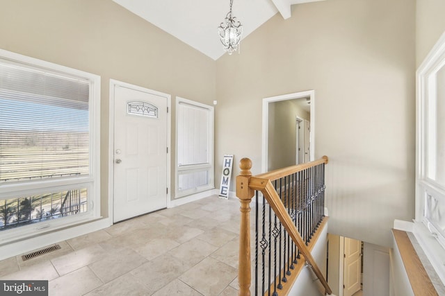 entryway featuring beam ceiling, high vaulted ceiling, and a chandelier