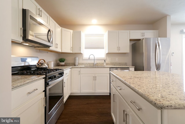 kitchen featuring white cabinets, sink, light stone countertops, and stainless steel appliances