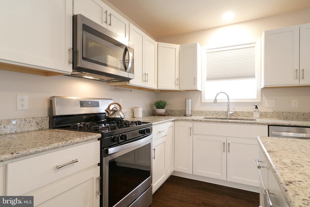 kitchen featuring light stone counters, sink, white cabinets, and stainless steel appliances