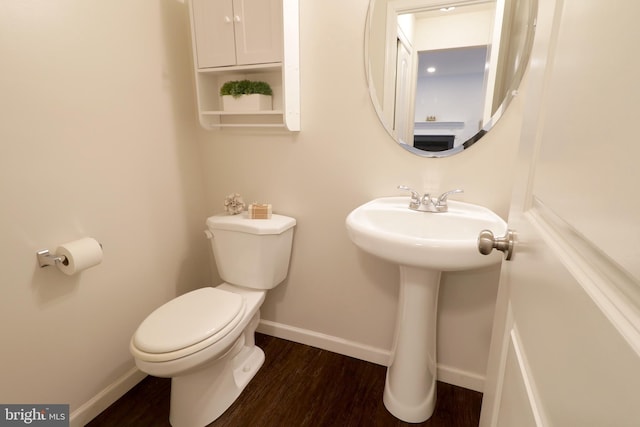 bathroom with wood-type flooring, toilet, and sink