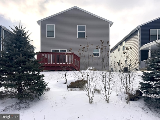 snow covered house with a wooden deck