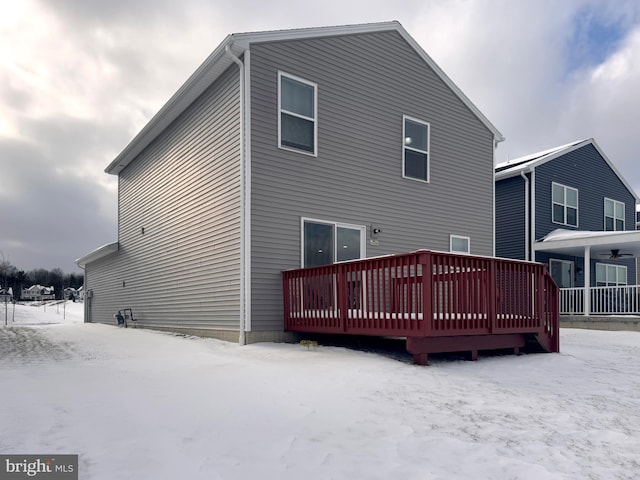 snow covered house with a wooden deck