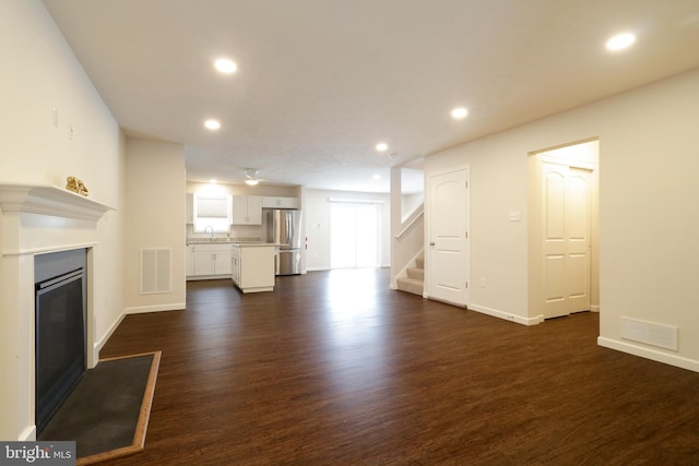 unfurnished living room featuring dark hardwood / wood-style flooring and sink