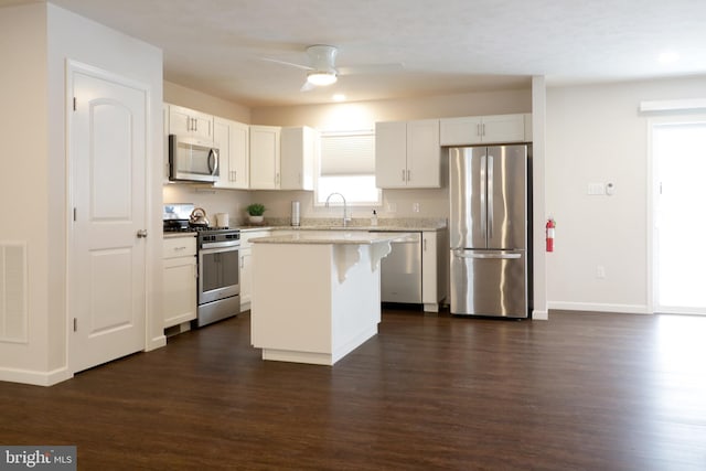 kitchen featuring a breakfast bar, appliances with stainless steel finishes, white cabinetry, and a kitchen island