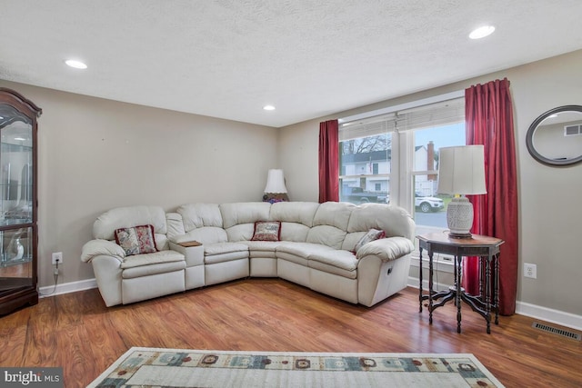 living room with hardwood / wood-style floors and a textured ceiling