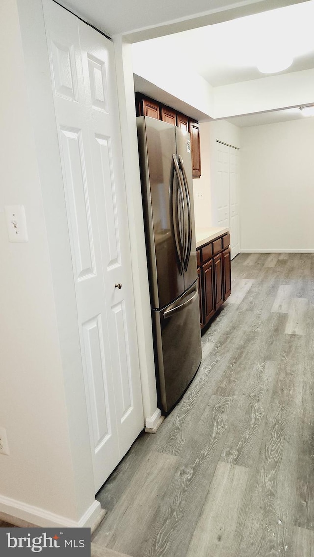 kitchen with light hardwood / wood-style floors and stainless steel fridge