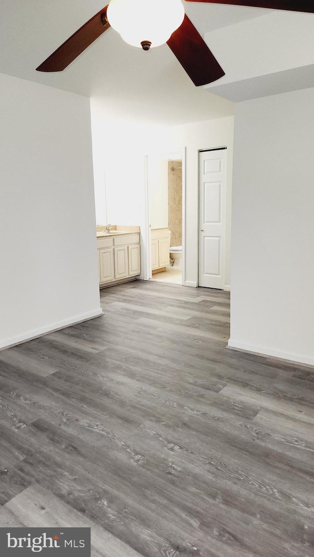 unfurnished room with ceiling fan, sink, and hardwood / wood-style flooring