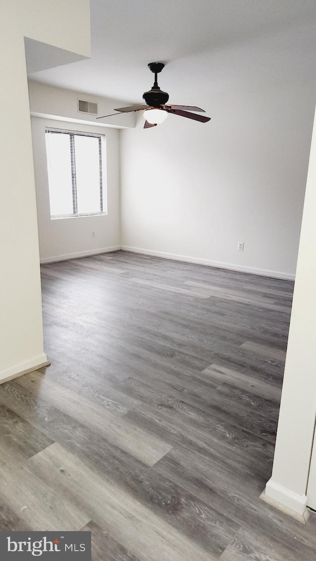 spare room featuring ceiling fan and dark hardwood / wood-style floors