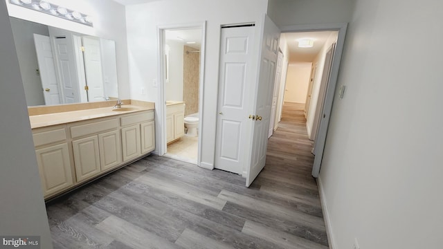 bathroom featuring toilet, hardwood / wood-style flooring, and vanity