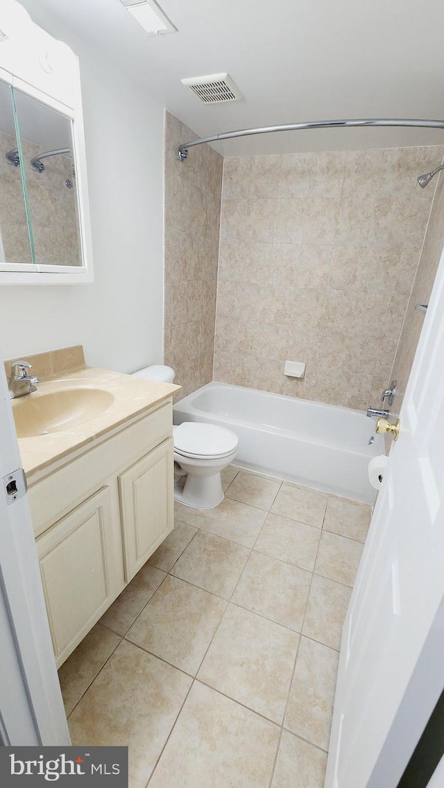 full bathroom with tiled shower / bath combo, vanity, toilet, and tile patterned flooring