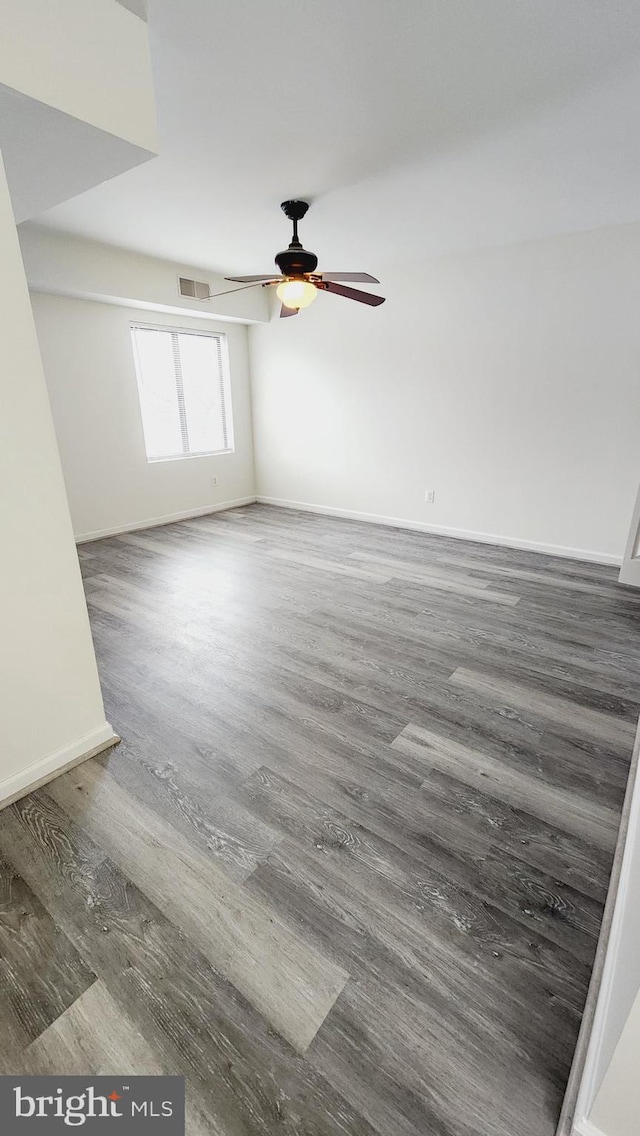 unfurnished room with ceiling fan and dark wood-type flooring