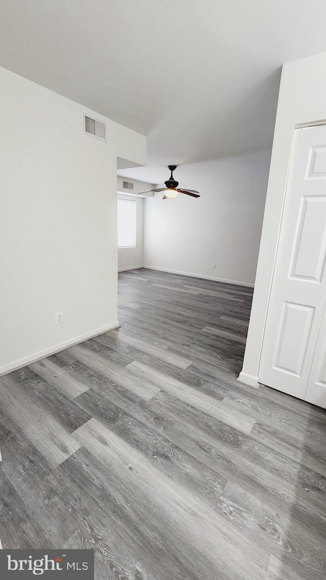 unfurnished living room with ceiling fan and wood-type flooring