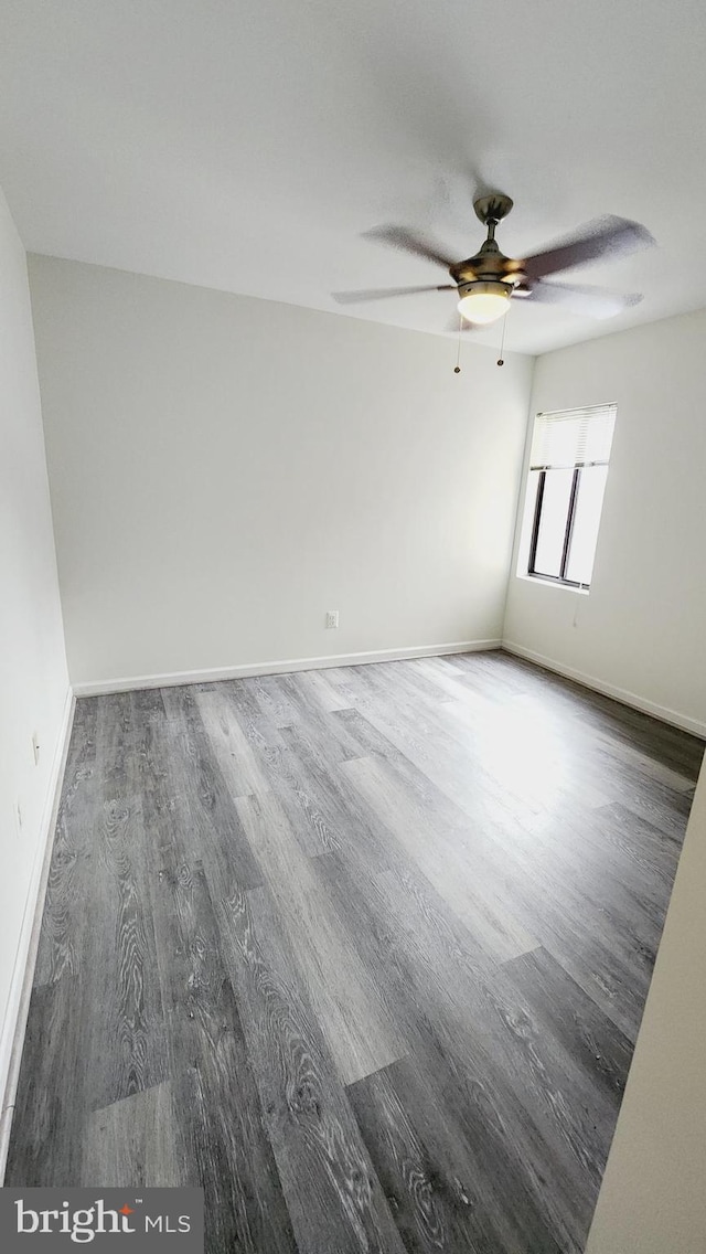 spare room featuring dark wood-type flooring and ceiling fan