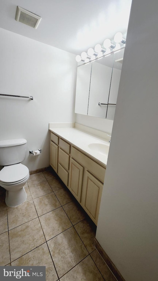 bathroom with toilet, tile patterned flooring, and vanity