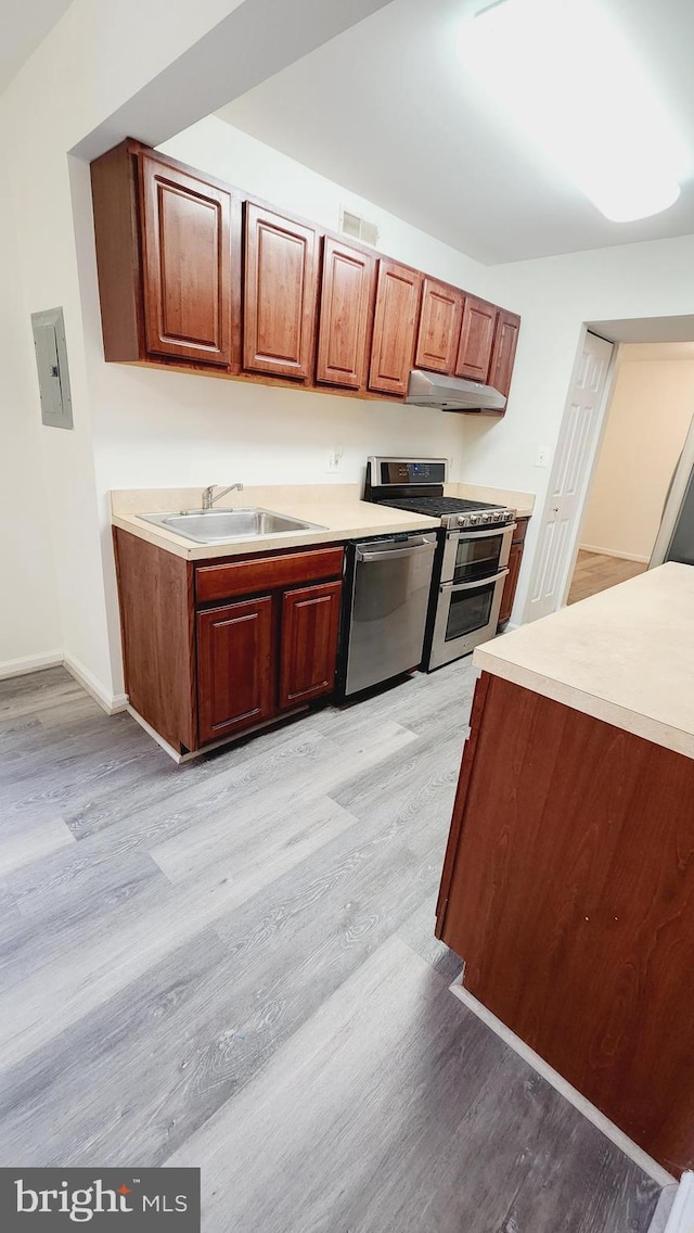 kitchen with stainless steel appliances, light hardwood / wood-style floors, and sink