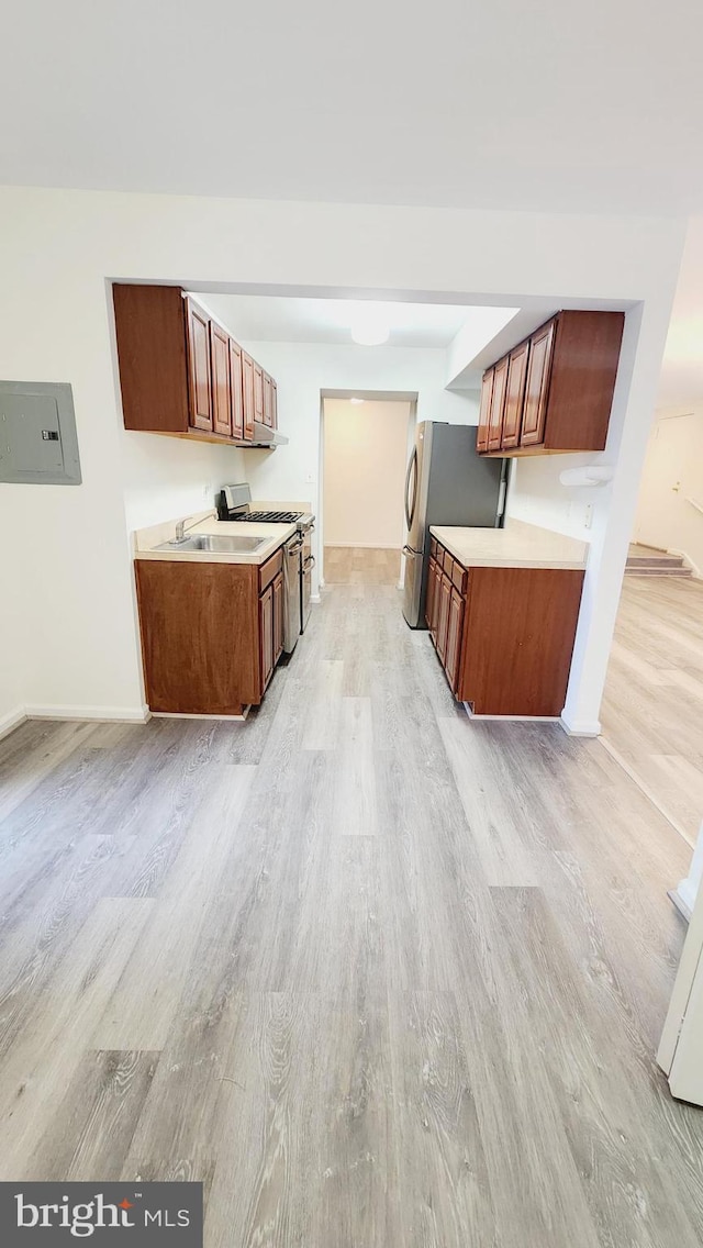 kitchen featuring stainless steel appliances, light hardwood / wood-style floors, and sink