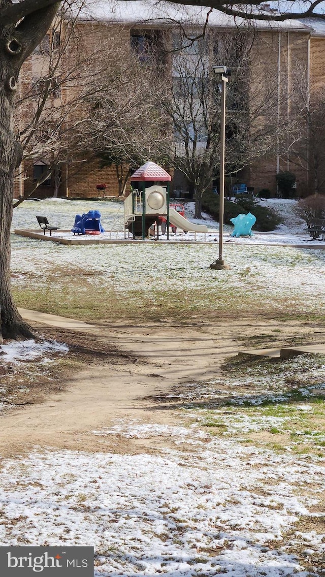 yard covered in snow featuring a playground