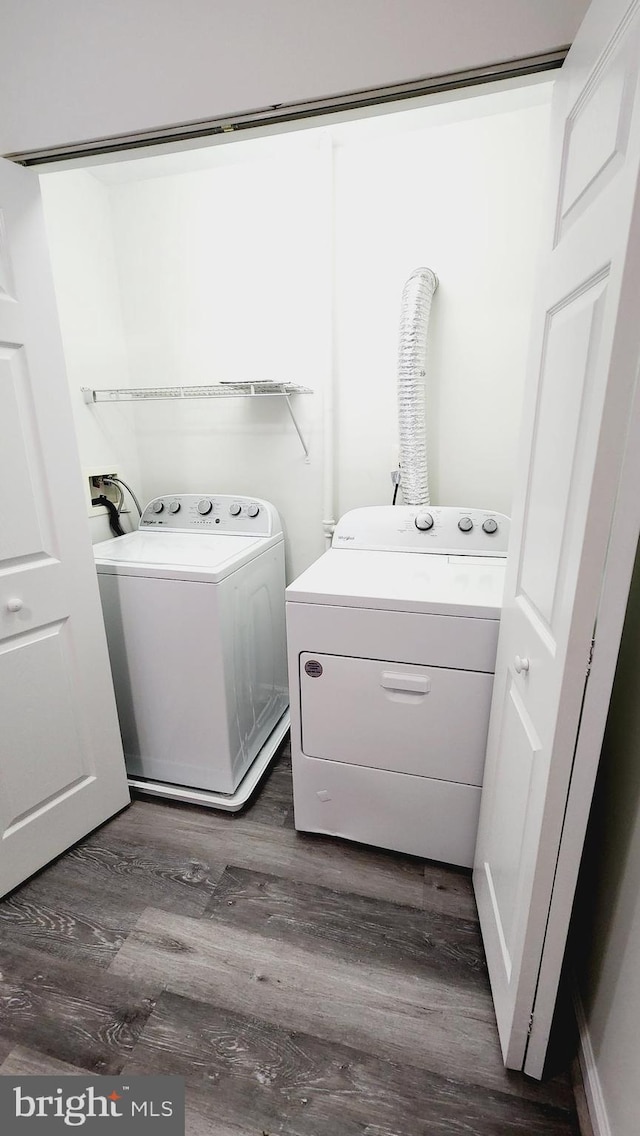 laundry room with washer and dryer and dark hardwood / wood-style floors