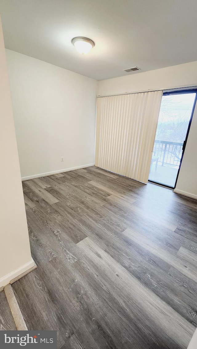 empty room with dark hardwood / wood-style flooring