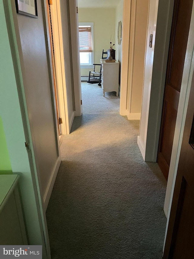 corridor featuring light carpet and baseboard heating