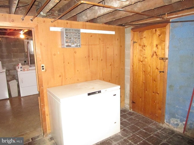 basement with washing machine and clothes dryer and fridge