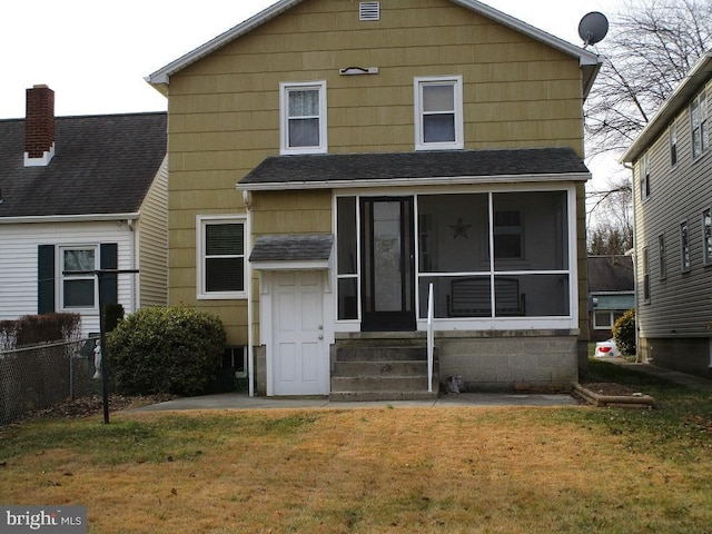 back of property featuring a sunroom and a lawn