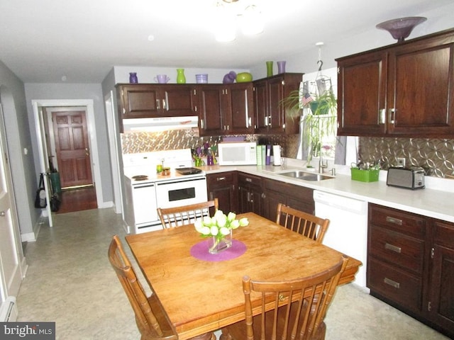 kitchen featuring sink, backsplash, dark brown cabinetry, and white appliances