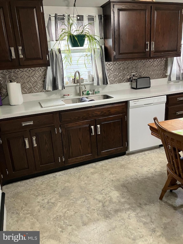 kitchen featuring white dishwasher, backsplash, dark brown cabinetry, and sink