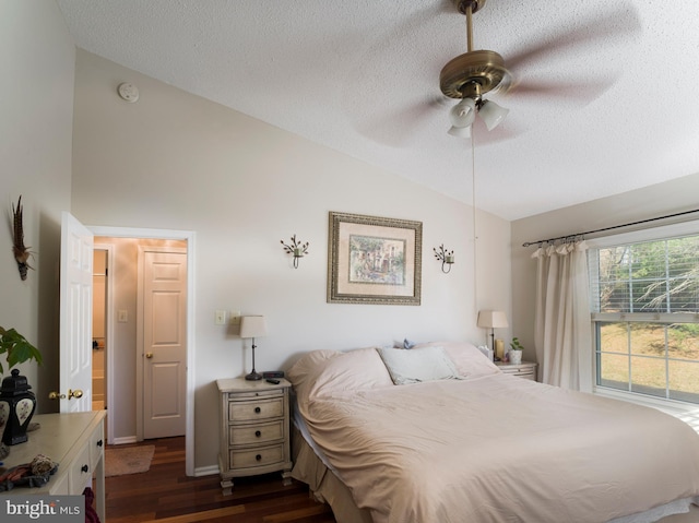 bedroom featuring lofted ceiling, ceiling fan, dark wood-type flooring, and a textured ceiling