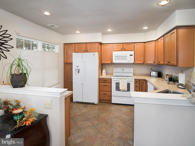 kitchen featuring kitchen peninsula, sink, and white appliances