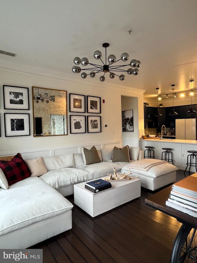 living room with hardwood / wood-style flooring, crown molding, and sink