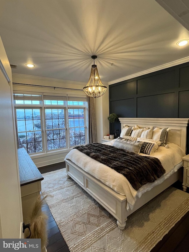 bedroom featuring light hardwood / wood-style floors, crown molding, and a chandelier