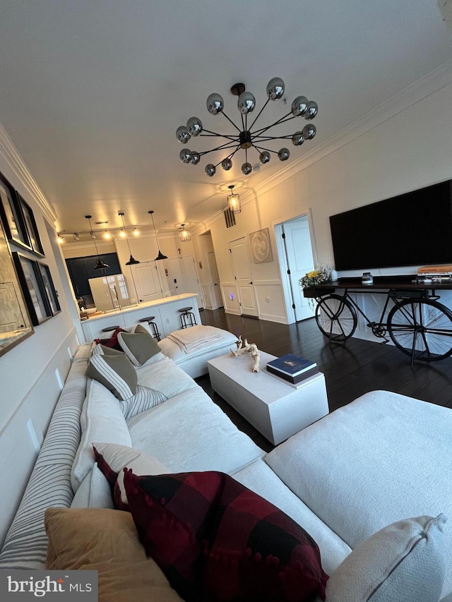 living room featuring a chandelier, crown molding, and dark wood-type flooring