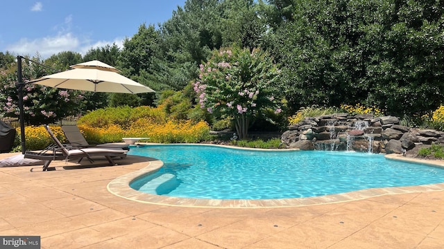 pool featuring a diving board and a patio area