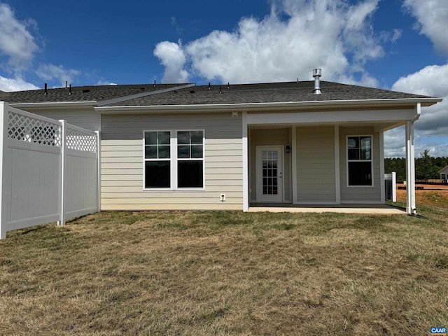 back of house featuring a lawn and a patio