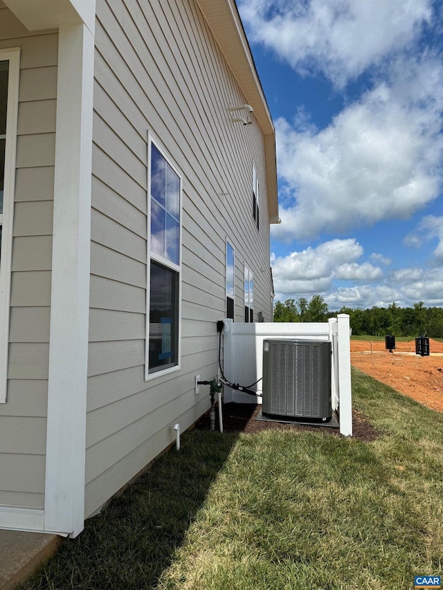 view of side of property featuring central air condition unit and a yard