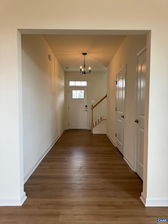 doorway to outside featuring dark hardwood / wood-style floors and an inviting chandelier