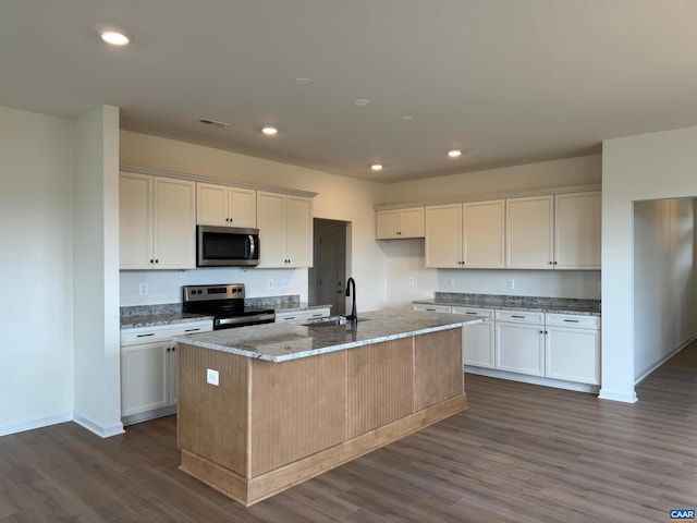 kitchen with white cabinetry, dark wood-type flooring, an island with sink, and stainless steel appliances