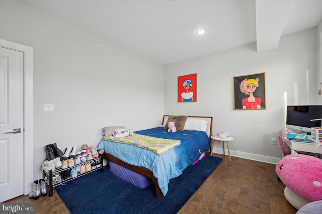 bedroom with beamed ceiling and dark hardwood / wood-style floors