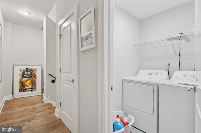 washroom with light hardwood / wood-style flooring and washing machine and clothes dryer