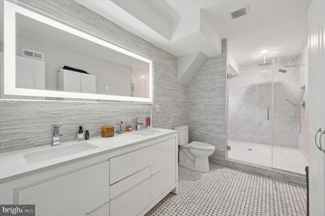 bathroom with vanity, a shower with door, backsplash, toilet, and tile walls