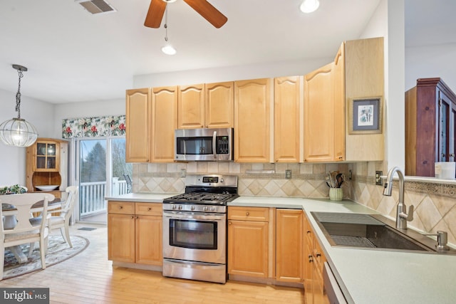 kitchen featuring tasteful backsplash, hanging light fixtures, stainless steel appliances, and sink