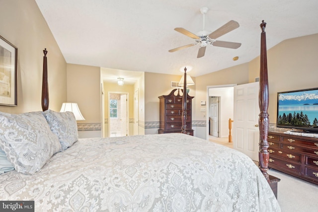 carpeted bedroom featuring ceiling fan, ensuite bathroom, and vaulted ceiling