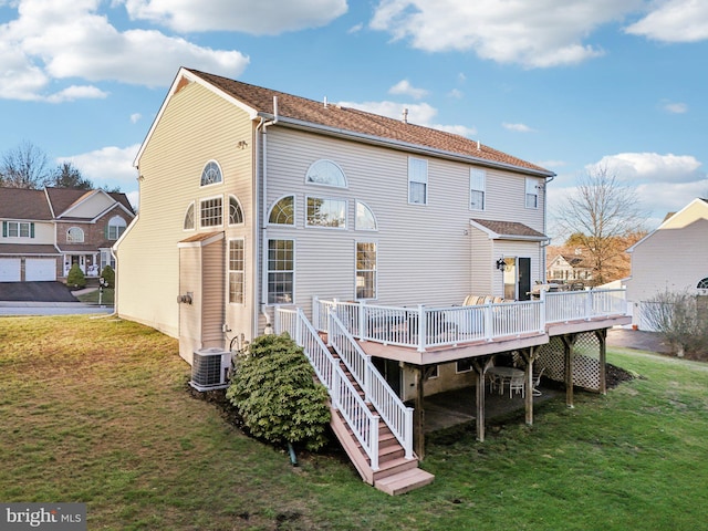 rear view of house featuring a lawn, central air condition unit, and a wooden deck