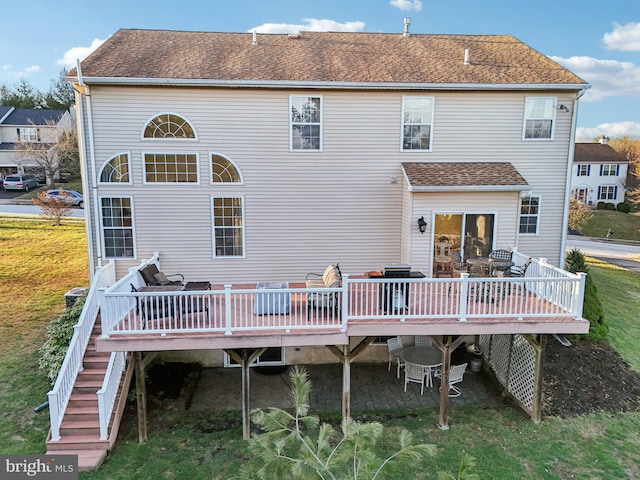 back of property with a lawn and a deck