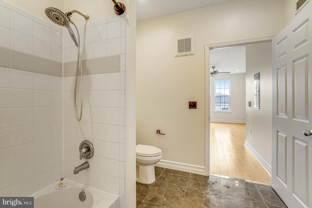 bathroom featuring toilet, baseboards, bathtub / shower combination, and visible vents